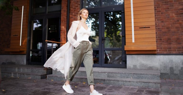 Woman with hands in her cargo pants pockets walking along the spavement