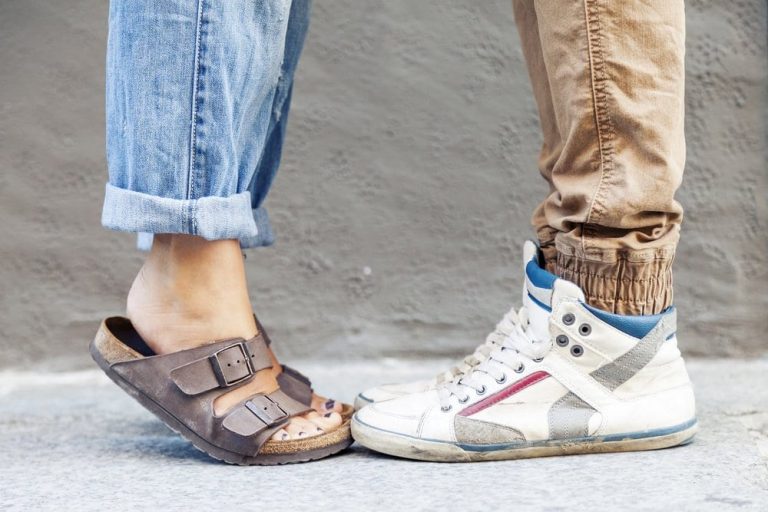 woman wearing boyfriend jeans next to man wearing brown corduroys and sneaker hi tops